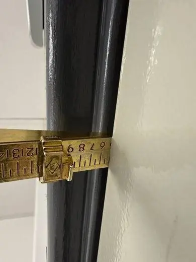 Measuring the gap at the edge of a fire door with a gauge