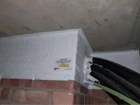Cable bundle through a compartment wall with fire stopping coating and label