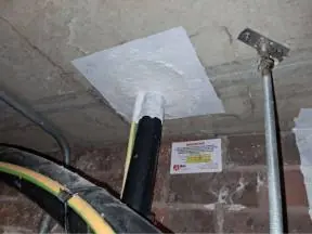 Cables passing through a compartment wall, sealed with fire stopping and labelled